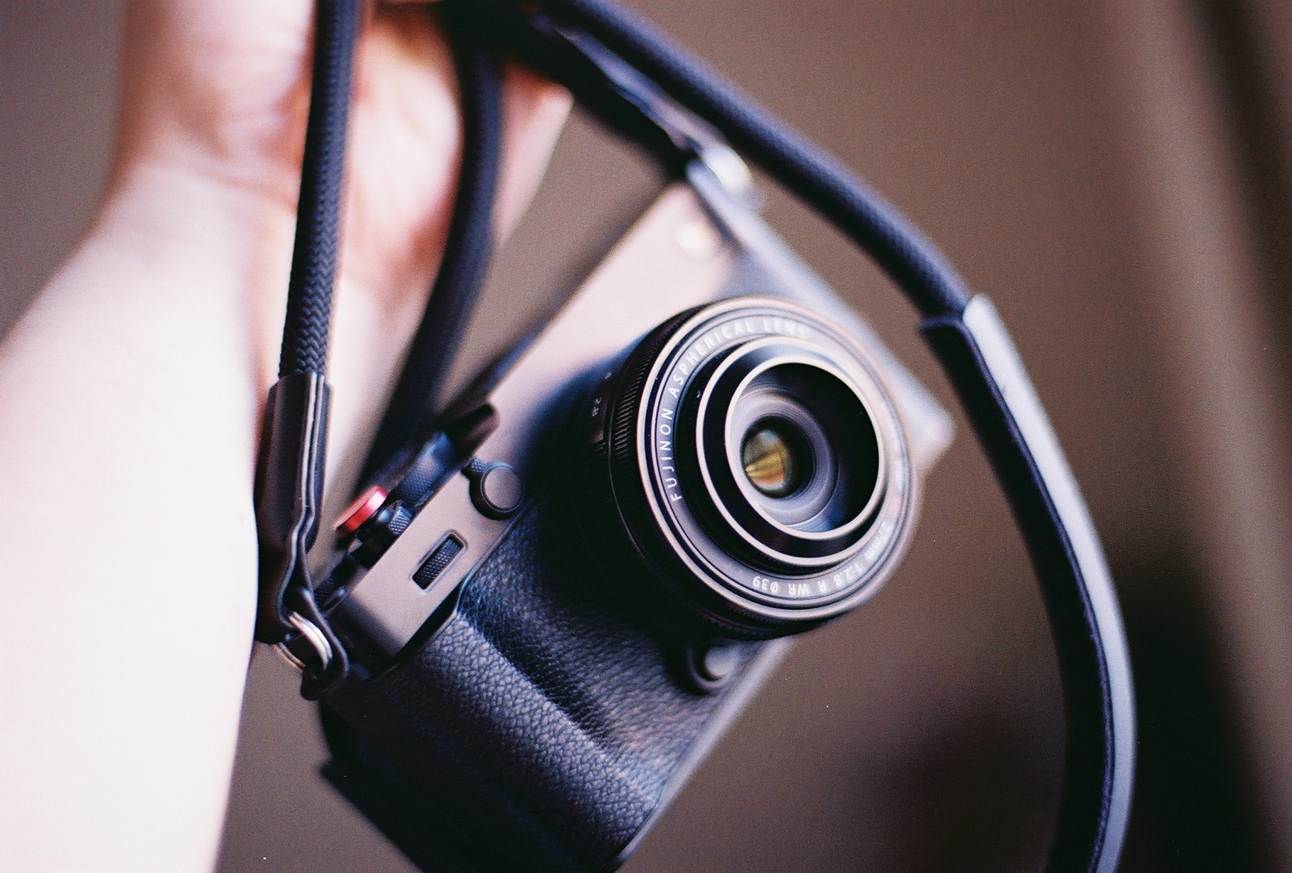 A close-up of a camera with its strap attached.